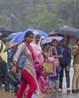 People wait for transport vehicles amid rain, in Bengaluru, on Monday (PTI) People wait for transport vehicles amid rain, in Bengaluru, on Monday (PTI)