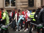 A fan is assisted by a police officer after multiple people were hit by a car during the Victory parade Action Images via Reuters/Lee Smith