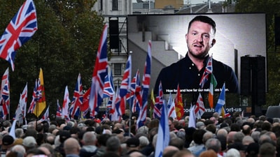 Tommy Robinson, anti-immigration activist, is displayed on a screen, as people attend an anti-immigration protest, in London, Britain, October 26, 2024. REUTERS/Chris J Ratcliffe/File Photo (REUTERS)