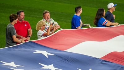 People hold a large U.S. flag in honor of Memorial Day during the playing of the national anthem prior to a baseball game between the Texas Rangers and the Toronto Blue Jays, Monday, May 26, 2025, in Arlington, Texas. (AP Photo/Julio Cortez) (AP) People hold a large U.S. flag in honor of Memorial Day during the playing of the national anthem prior to a baseball game between the Texas Rangers and the Toronto Blue Jays, Monday, May 26, 2025, in Arlington, Texas. (AP Photo/Julio Cortez) (AP)
