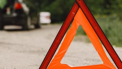Driver putting warning triangle on asphalt road. Emergency stop concept. Driver putting warning triangle on asphalt road. Emergency stop concept.
