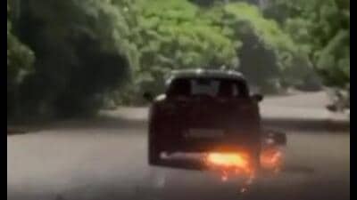 The clip, recorded near Omaxe R1 in the Sushant Golf City area, purportedly shows a two-wheeler stuck under a moving car, with sparks flying as it is pulled along the road. (Sourced)