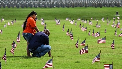 A man an a girl visit a grave, at the Houston National Cemetery on Memorial day, in Houston, Texas, on May 26, 2025. (Photo by RONALDO SCHEMIDT / AFP) (AFP) A man an a girl visit a grave, at the Houston National Cemetery on Memorial day, in Houston, Texas, on May 26, 2025. (Photo by RONALDO SCHEMIDT / AFP) (AFP)