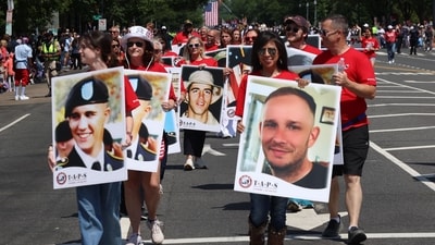 People carry photographs of military veterans as they participate in the National Memorial Day Parade on Constitution Avenue in Washington, DC, on May 26, 2025. (Photo by ALEX WROBLEWSKI / AFP) (AFP) People carry photographs of military veterans as they participate in the National Memorial Day Parade on Constitution Avenue in Washington, DC, on May 26, 2025. (Photo by ALEX WROBLEWSKI / AFP) (AFP)