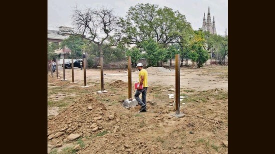 Fencing pillars being erected on the sports ground of Government College for Girls to turn it into a parking space for people visiting Shri Durga Mata Mandir in Ludhiana on Monday. (Gurpreet Singh/HT)