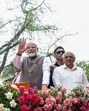 Prime Minister Narendra Modi waves to the gathering during a roadshow, in Gandhinagar on Tuesday. (ANI)