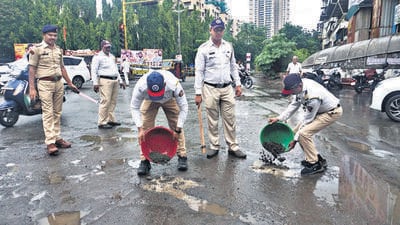 Traffic police officers filled potholes at the Nitin Company junction in Thane on Wednesday. (Praful Gangurde /HT Photo) Traffic police officers filled potholes at the Nitin Company junction in Thane on Wednesday. (Praful Gangurde /HT Photo)