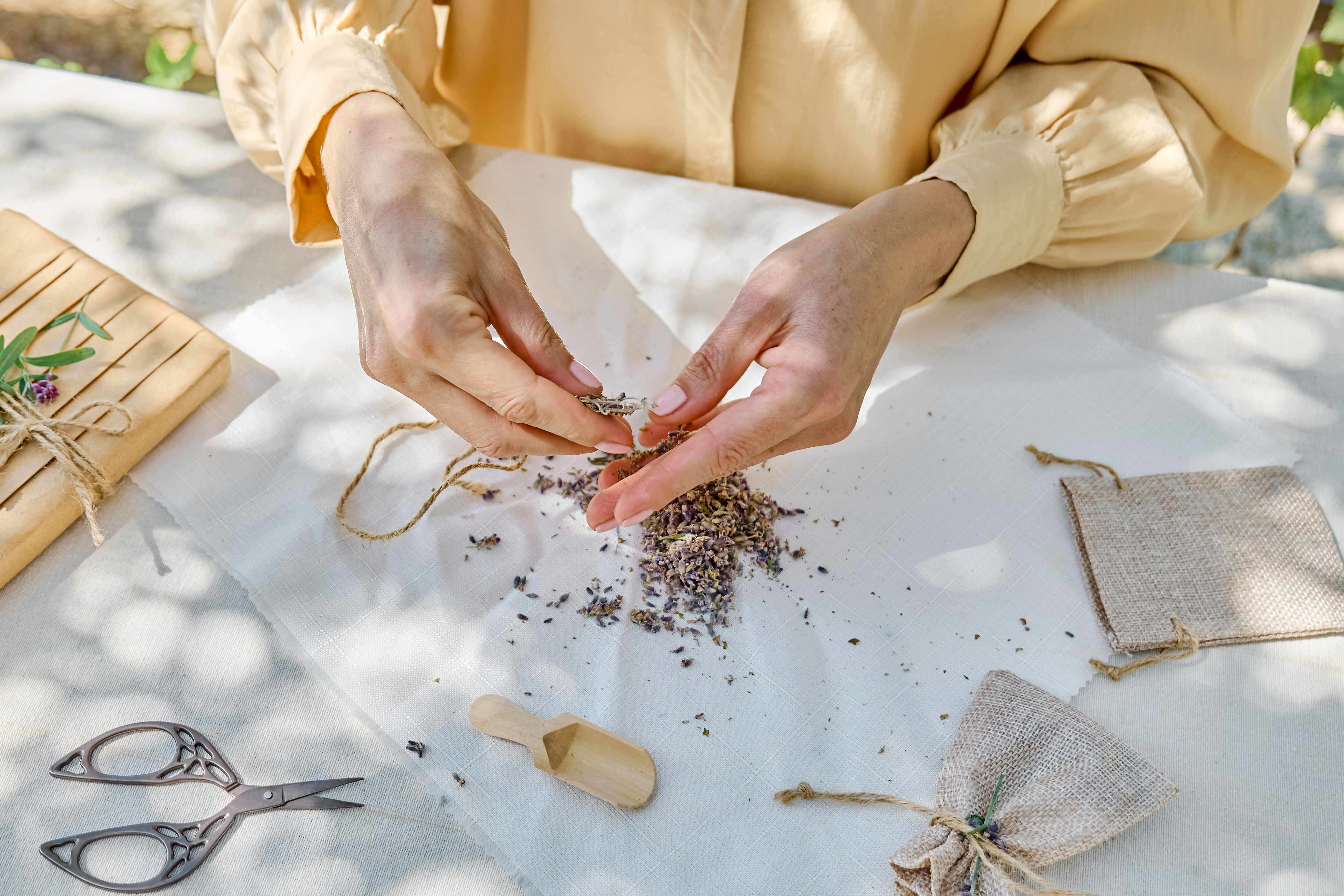 Filling potli bags with naturally scented herbs.