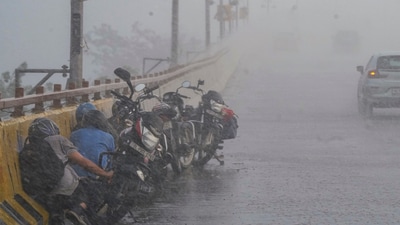Bike commuters take cover on the side of a road amid heavy rainfall, in Ghaziabad, Uttar Pradesh. (PTI file) Bike commuters take cover on the side of a road amid heavy rainfall, in Ghaziabad, Uttar Pradesh. (PTI file)
