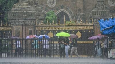 People commute amid torrential rains in Mumbai on Wednesday. (ANI Photo)