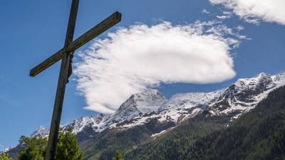 This photograph shows a Christ cross with in background the Bietschhorn mountain in Ferden on May 29, 2025, the day after the Birch Glacier collapsed and partially destroyed the small village of Blatten in the Swiss Alps. A massive glacier collapse on May 28, 2025 in southern Switzerland partially destroyed the small village of Blatten, which had been completely evacuated last week due to the impending danger, officials said. Around 3:30 pm (1330 GMT) a huge collapse occurred on the Birch Glacier, emergency services in the Wallis region said. (Photo by FABRICE COFFRINI / AFP) (AFP) This photograph shows a Christ cross with in background the Bietschhorn mountain in Ferden on May 29, 2025, the day after the Birch Glacier collapsed and partially destroyed the small village of Blatten in the Swiss Alps. A massive glacier collapse on May 28, 2025 in southern Switzerland partially destroyed the small village of Blatten, which had been completely evacuated last week due to the impending danger, officials said. Around 3:30 pm (1330 GMT) a huge collapse occurred on the Birch Glacier, emergency services in the Wallis region said. (Photo by FABRICE COFFRINI / AFP) (AFP)