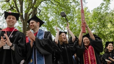 CAMBRIDGE, MASSACHUSETTS - MAY 29: Graduates from the Harvard School of Dental Medicine celebrate during their commencement ceremony on May 29, 2025 in Cambridge, Massachusetts. The joyous occasion unfolds amid escalating tensions between Harvard and the Trump administration, which has ordered the cancellation of federal contracts valued at approximately $100 million. Libby O'Neill/Getty Images/AFP (Photo by Libby O'Neill / GETTY IMAGES NORTH AMERICA / Getty Images via AFP) (Getty Images via AFP) CAMBRIDGE, MASSACHUSETTS - MAY 29: Graduates from the Harvard School of Dental Medicine celebrate during their commencement ceremony on May 29, 2025 in Cambridge, Massachusetts. The joyous occasion unfolds amid escalating tensions between Harvard and the Trump administration, which has ordered the cancellation of federal contracts valued at approximately $100 million. Libby O'Neill/Getty Images/AFP (Photo by Libby O'Neill / GETTY IMAGES NORTH AMERICA / Getty Images via AFP) (Getty Images via AFP)