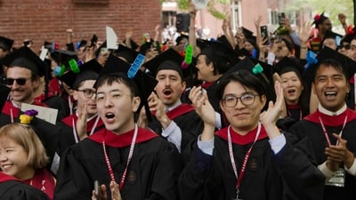 CAMBRIDGE, MASSACHUSETTS - MAY 29: Graduates from Harvard Graduate School of Design celebrate during their commencement ceremony on May 29, 2025 in Cambridge, Massachusetts. The joyous occasion unfolds amid escalating tensions between Harvard and the Trump administration, which has ordered the cancellation of federal contracts valued at approximately $100 million. Libby O'Neill/Getty Images/AFP (Photo by Libby O'Neill / GETTY IMAGES NORTH AMERICA / Getty Images via AFP) (Getty Images via AFP) CAMBRIDGE, MASSACHUSETTS - MAY 29: Graduates from Harvard Graduate School of Design celebrate during their commencement ceremony on May 29, 2025 in Cambridge, Massachusetts. The joyous occasion unfolds amid escalating tensions between Harvard and the Trump administration, which has ordered the cancellation of federal contracts valued at approximately $100 million. Libby O'Neill/Getty Images/AFP (Photo by Libby O'Neill / GETTY IMAGES NORTH AMERICA / Getty Images via AFP) (Getty Images via AFP)