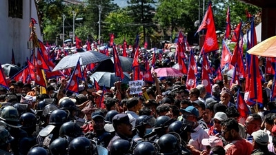 Security personnel stand guard as demonstrators carrying Nepal's national flag take part in a pro-monarchy rally in Kathmandu (AFP) Security personnel stand guard as demonstrators carrying Nepal's national flag take part in a pro-monarchy rally in Kathmandu (AFP)