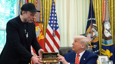 President Donald Trump, right, presents a key to Elon Musk during a news conference in the Oval Office of the White House, Friday, May 30, 2025, in Washington. (AP)