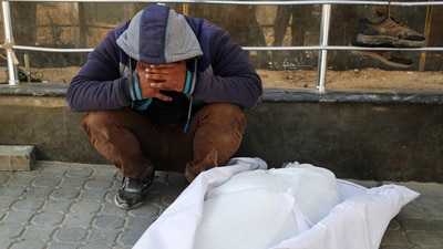 A mourner reacts next to the body of a Palestinian killed in Israeli strikes, at Al Shifa hospital, in Gaza City, May 30. (REUTERS)