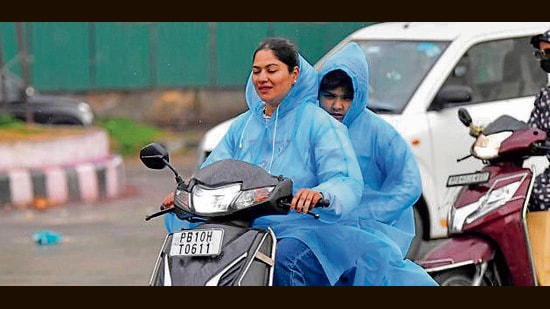 Commuters make their way during rain in Ludhiana on Saturday. (Manish/HT)
