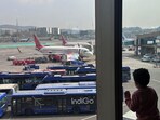 A boy looks at Air India airline passenger aircraft parked at the Chhatrapati Shivaji Maharaj International Airport in Mumbai