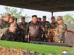 This picture taken on May 29, 2025 shows North Korea's leader Kim Jong Un (C) observing a display by the artillery divisions at an undisclosed location. 