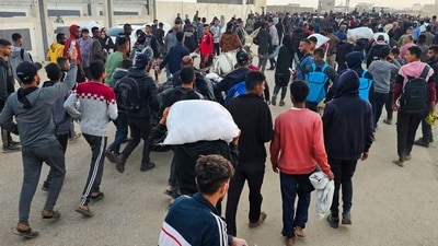 Displaced Palestinians, some carrying sacks of food, leave a distribution centre in Rafah, (AFP) Displaced Palestinians, some carrying sacks of food, leave a distribution centre in Rafah, (AFP)
