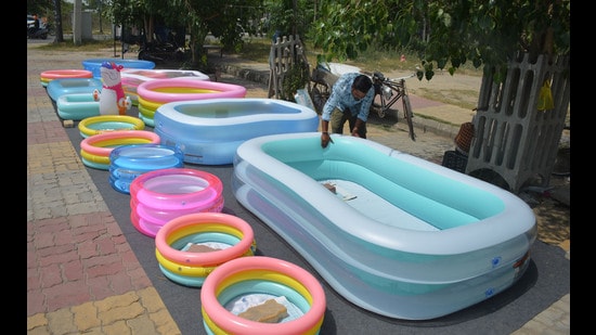 A vendor adjusts his display of paddling pools for sale on the roadside during a hot summer day in Amritsar on Sunday. (Sameer Sehgal/Hindustan Times)