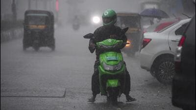 A commuter rides a two-wheeler amid heavy rainfall in Mumbai. (PTI Photo) A commuter rides a two-wheeler amid heavy rainfall in Mumbai. (PTI Photo)