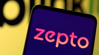 Zepto logo is seen on smartphone in front of Blinkit logo in this illustration. (REUTERS)