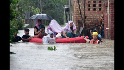 Flood-affected people being moved to safer places through a water-logged road during rains in Imphal East, Manipur, on Monday. (REUTERS)