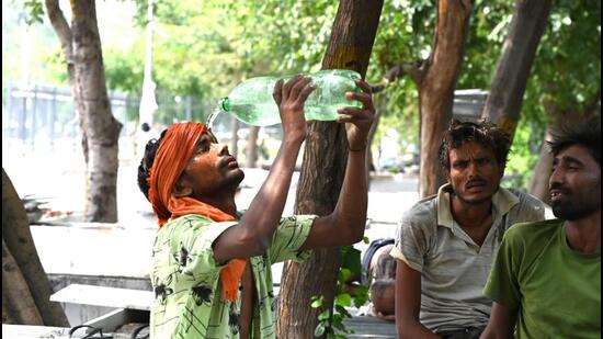 A worker pours water on himself to cool off water during hot weather near Rajghat in New Delhi, India, on May 31. (Hindustan Times)