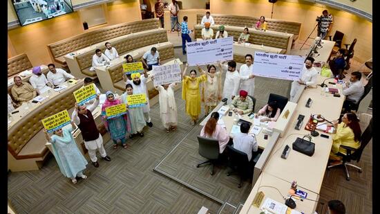 Congress and AAP councillors protesting during the House meeting at MC office in Chandigarh on Tuesday. (Ravi Kumar/HT)