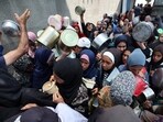 Palestinian women gather at a hot meal distribution point in Nuseirat in the central Gaza Strip, Palestinian women gather at a hot meal distribution point in Nuseirat in the central Gaza Strip,
