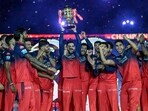Royal Challengers Bengaluru's Virat Kohli, along with his teammates, celebrates with the trophy after winning the Indian Premier League (IPL) Twenty20 final cricket match against Punjab Kings