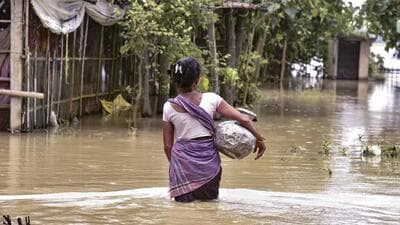 A woman wades through floodwater in Assam’s Morigaon district on Wednesday. (PTI) A woman wades through floodwater in Assam’s Morigaon district on Wednesday. (PTI)
