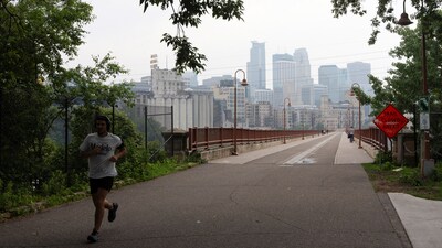 A person runs near the Stone Arch Bridge as a haze from Canadian wildfire smoke causes poor air quality in Minneapolis, Minnesota, U.S., June 3, 2025. (REUTERS)