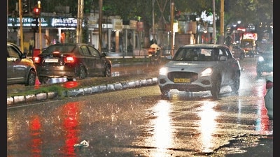Commuters brave the rain at Sector 22 in Chandigarh on Wednesday night. (Keshav Singh/HT)