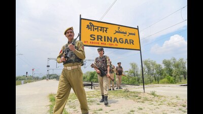 Jammu and Kashmir Police personnel patrol near the railway track at Srinagar railway station on Wednesday. (ANI)