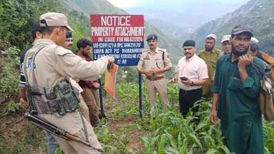 Police officials install a notice regarding property attachment in Sumbad village of Ramban ditrict. (HT photo)