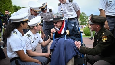 Attendees shared a lighthearted moment with 102-year-old World War II and D-Day veteran Jake Larson, affectionately known as “Papa Jake,” ahead of a memorial ceremony at the American Cemetery in Colleville-sur-Mer on June 6, 2025. (Photo by Lou BENOIST / AFP) (AFP) Attendees shared a lighthearted moment with 102-year-old World War II and D-Day veteran Jake Larson, affectionately known as “Papa Jake,” ahead of a memorial ceremony at the American Cemetery in Colleville-sur-Mer on June 6, 2025. (Photo by Lou BENOIST / AFP) (AFP)