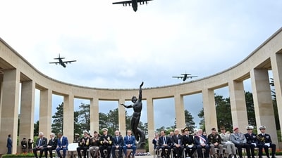 Military aircraft flew in formation over the American Cemetery in Colleville-sur-Mer as U.S. Secretary of Defense Pete Hegseth and French Defence Minister Sébastien Lecornu looked on during a memorial ceremony on June 6, 2025. The flyover was part of the commemorations marking the 81st anniversary of the D-Day landings. (Photo by Lou BENOIST / AFP) (AFP) Military aircraft flew in formation over the American Cemetery in Colleville-sur-Mer as U.S. Secretary of Defense Pete Hegseth and French Defence Minister Sébastien Lecornu looked on during a memorial ceremony on June 6, 2025. The flyover was part of the commemorations marking the 81st anniversary of the D-Day landings. (Photo by Lou BENOIST / AFP) (AFP)