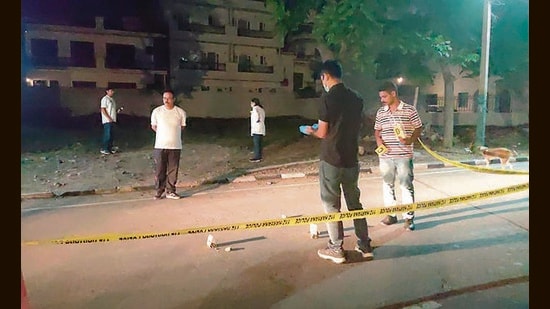 Police and forensic experts collecting evidence from the crime scene at the mall in Panchkula’s Amravati Enclave on Thursday night. (Sant Arora/HT)