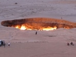 (FILES) A picture taken on May 3, 2014, shows people visiting "The Gateway to Hell," a huge burning gas crater in the heart of Turkmenistan's Karakum desert.