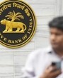 People walk past the Reserve Bank of India (RBI) logo outside its headquarters, in Mumbai. (PTI) People walk past the Reserve Bank of India (RBI) logo outside its headquarters, in Mumbai. (PTI)