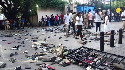 Fans stand next to abandoned shoes and a fallen barrier following a stampede during celebrations. (AFP)