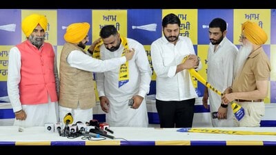 Councillor Satnam Singh Sunny Master being welcomed into the AAP by cabinet minister Tarunpreet Singh Sondh. (HT Photo)