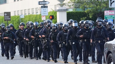 Los Angeles Police officers assembled during a protest after a federal immigration operation on Friday. Officers with protective shields stood shoulder to shoulder blocking an entrance, used tear gas to disperse crowds, and, wearing helmets and carrying batons, gradually pushed protesters down the street. (AP) Los Angeles Police officers assembled during a protest after a federal immigration operation on Friday. Officers with protective shields stood shoulder to shoulder blocking an entrance, used tear gas to disperse crowds, and, wearing helmets and carrying batons, gradually pushed protesters down the street. (AP)