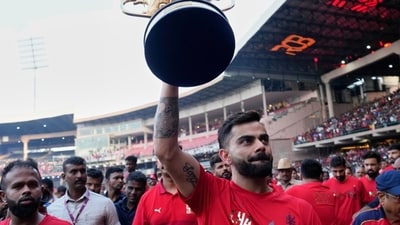 Virat Kohli with the IPL trophy in front of fans at the Chinnaswamy Stadium on Wednesday (PTI) Virat Kohli with the IPL trophy in front of fans at the Chinnaswamy Stadium on Wednesday (PTI)