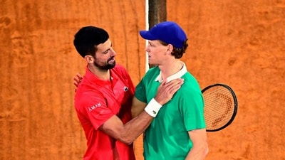 Winner Italy's Jannik Sinner cheers Serbia's Novak Djokovic (L) at the end of their men's singles semi-final match. (AFP)