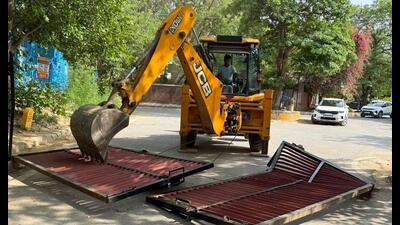 Workers from the enforcement wing of the DTCP demolish illegal gates installed without permission from the authorities in South City 1, in Gurugram. (PARVEEN KUMAR) Workers from the enforcement wing of the DTCP demolish illegal gates installed without permission from the authorities in South City 1, in Gurugram. (PARVEEN KUMAR)