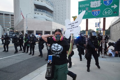 A protester stands in front of Los Angeles Police Department officers attempting to disperse a protest after federal immigration authorities conducted an operation. (AP) A protester stands in front of Los Angeles Police Department officers attempting to disperse a protest after federal immigration authorities conducted an operation. (AP)