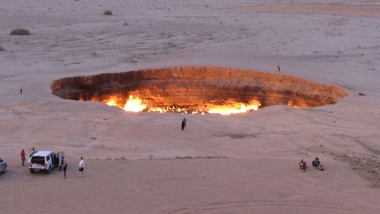 (FILES) A picture taken on May 3, 2014, shows people visiting "The Gateway to Hell," a huge burning gas crater in the heart of Turkmenistan's Karakum desert. (AFP)